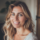 Portrait d'une femme souriante aux cheveux blonds.